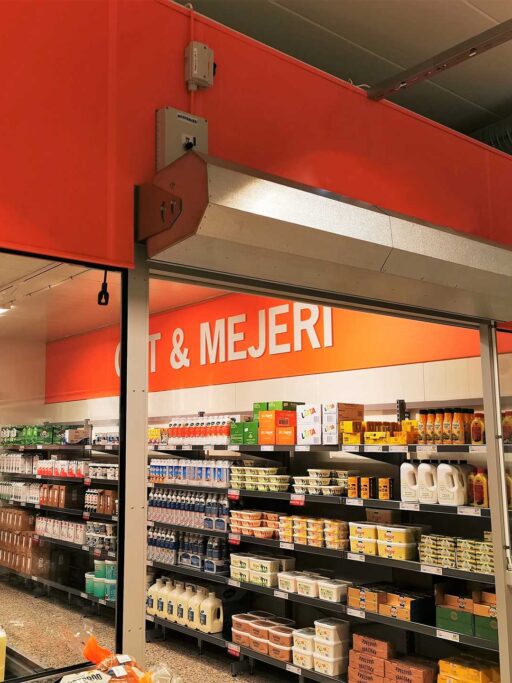 En Masterveil AC 1000 luftridå installerad ovanför ingången till ett kylrum för mejeriprodukter.