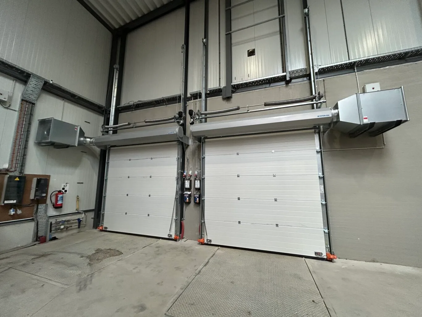 2 Industriporte med overliggende Masterveil lufttæpper skaber barriere mod flyvende insekter